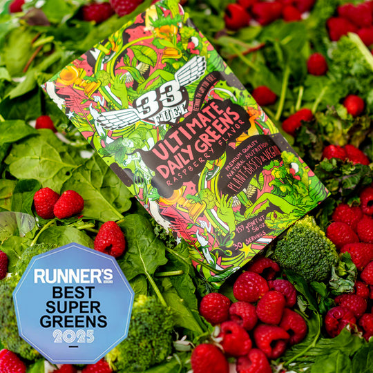 Greens powder  Ultimate Daily Greens' surrounded by fresh vegetables and berries. Award Runner's world BEST SUPER GREENS 2025